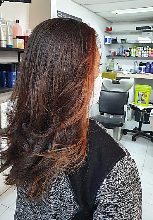 Melena en capas castaño oscuro con puntas cobre, de lado