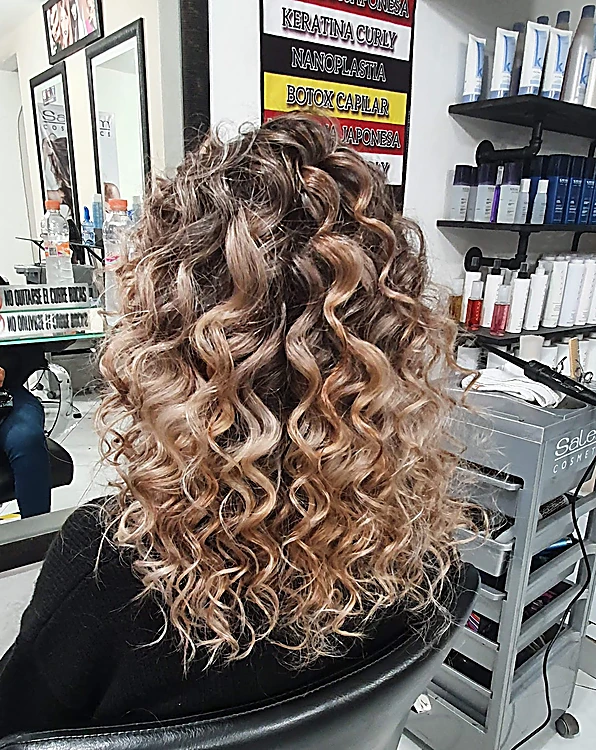 Rizos definidos con luces rubias, de espaldas